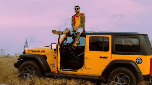 Ryan Castro encima de un vehículo 4X4 amarillo.